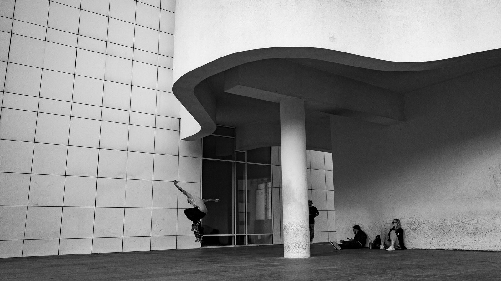 Arquitectura blanca curva con figuras a la sombra