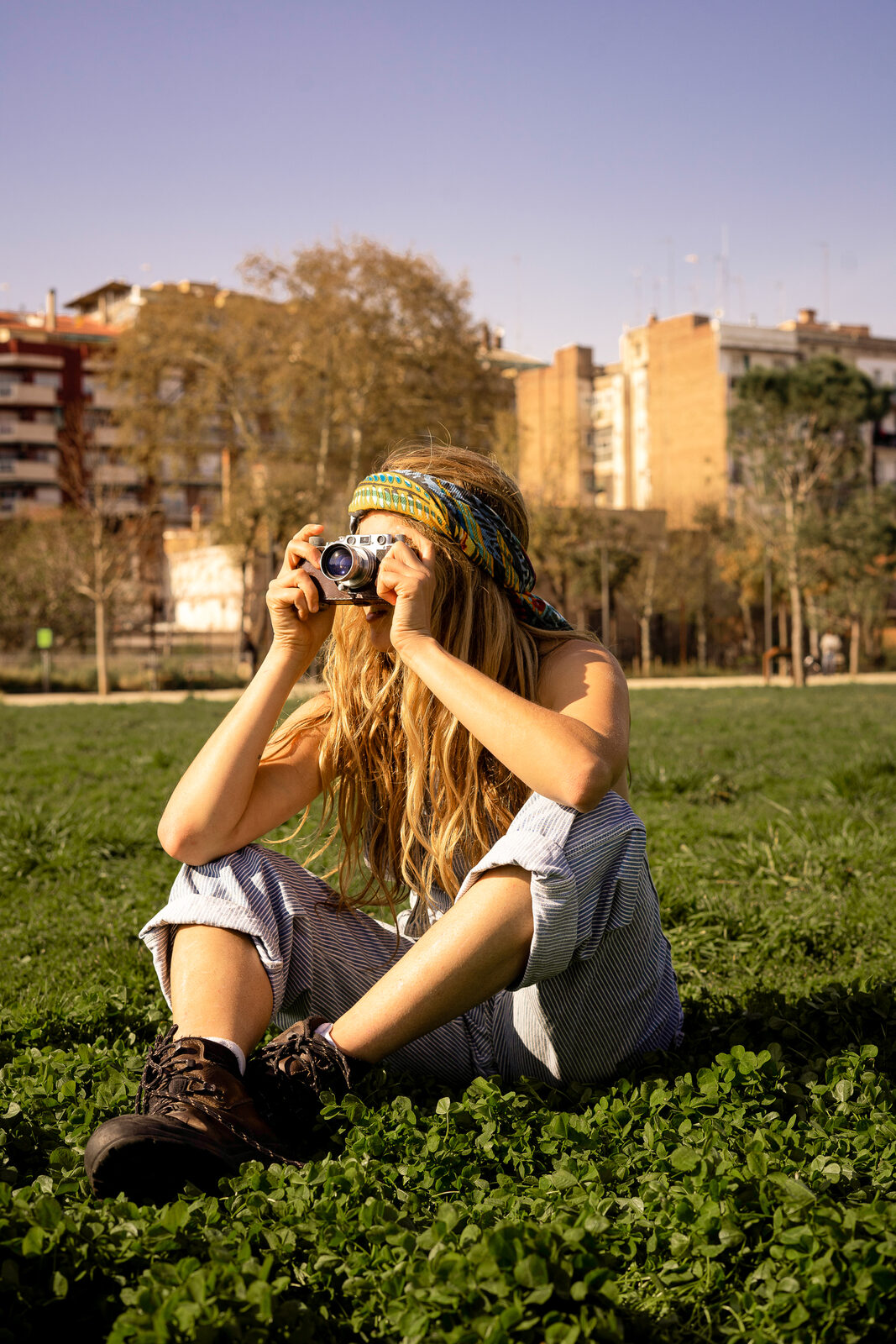 Mujer fotografiando con cámara analógica en el parque