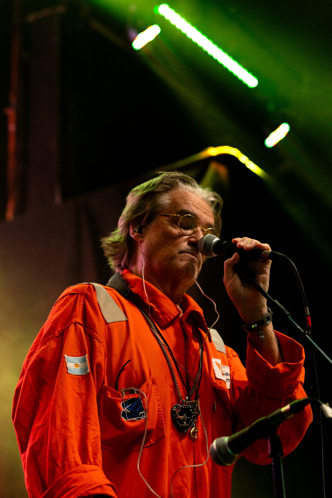 Músico cantando al micrófono, mameluco naranja