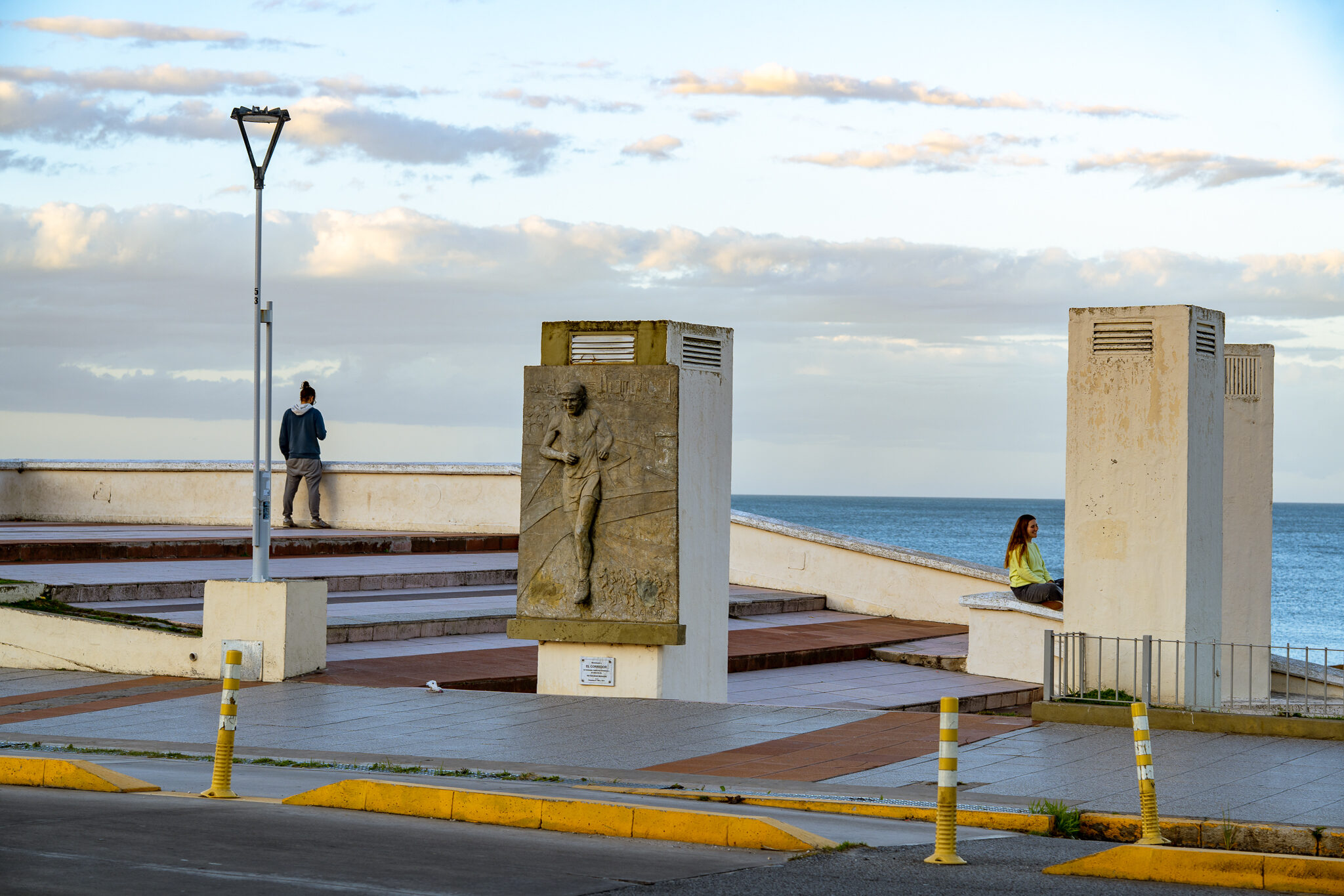 Costa al amanecer — figura junto a monumento